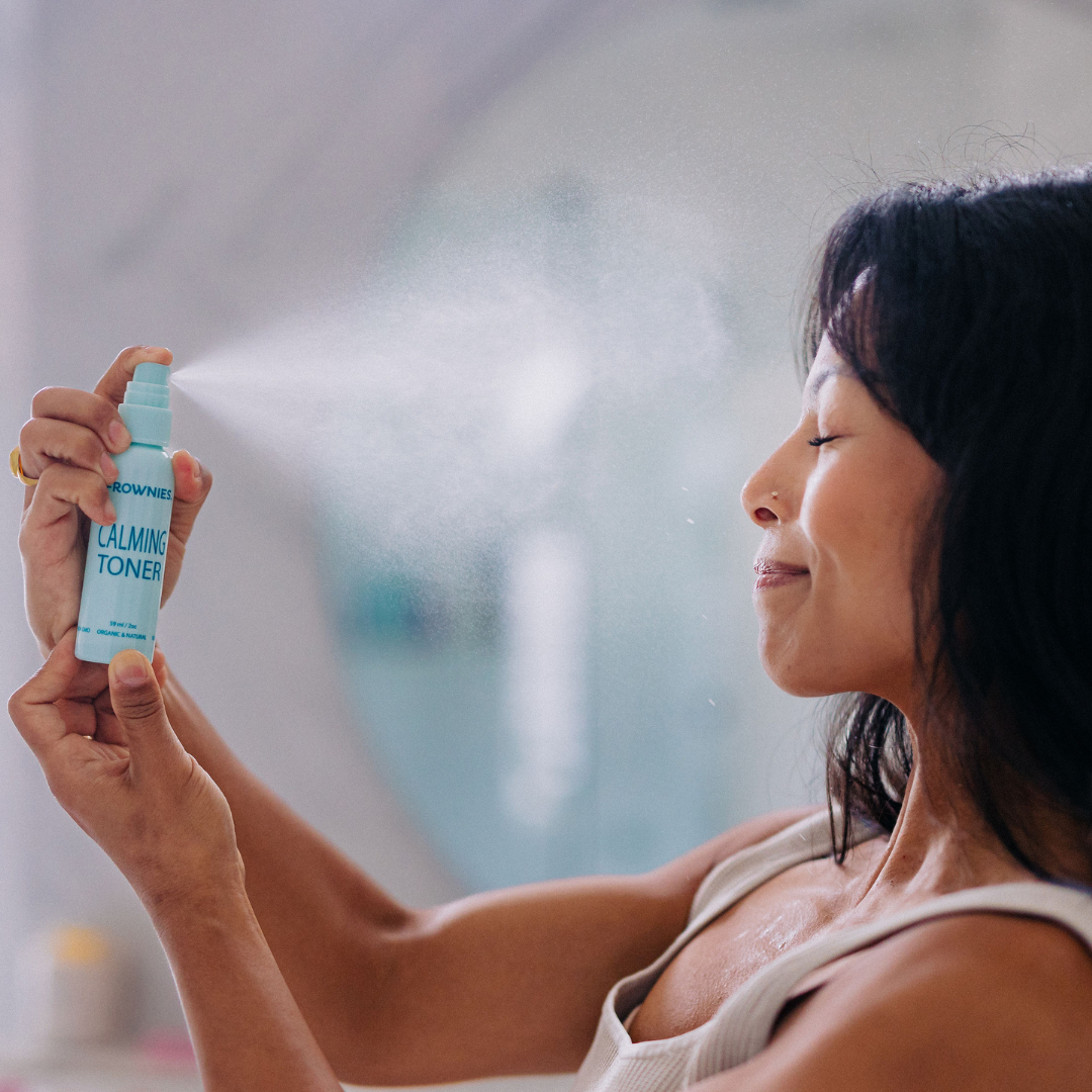 Frownies calming toner being sprayed on a woman's face 