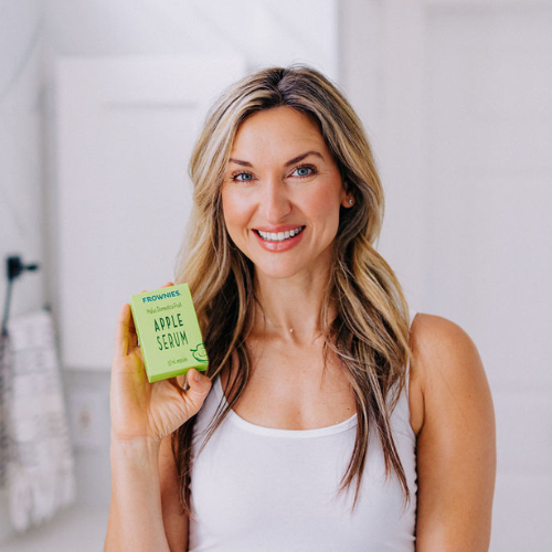 Frownies apple serum being held by a woman with dirty blonde hair 