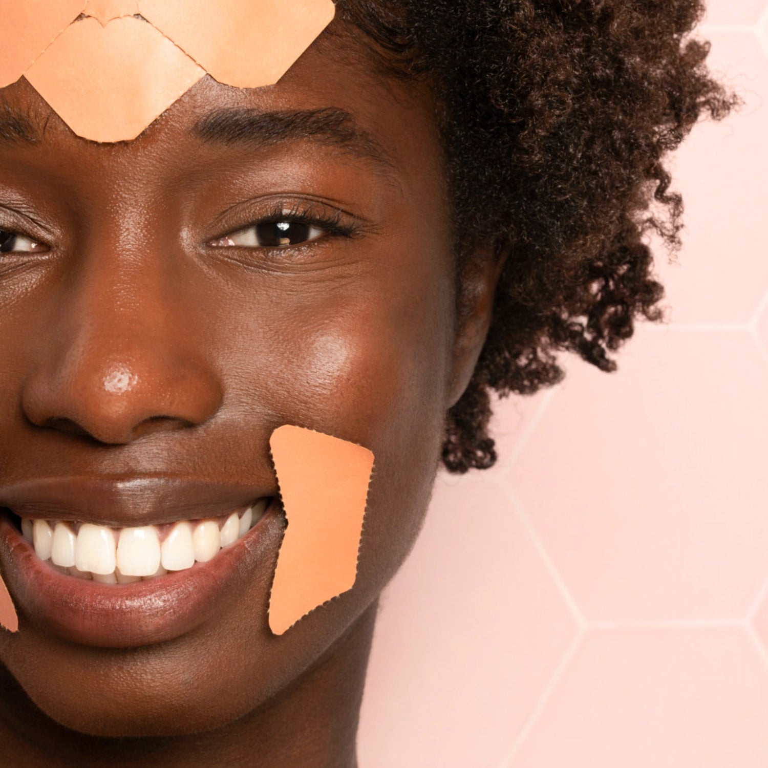 Close-up of a Black woman smiling while wearing Frownies Corners of Eyes and Mouth (CEM) facial patches.