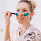 Frownies blue green algae clay mask being applied to a womans face with the brush 