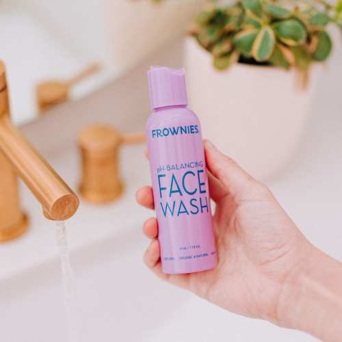 Frownies pH-balancing face wash being held over a sink