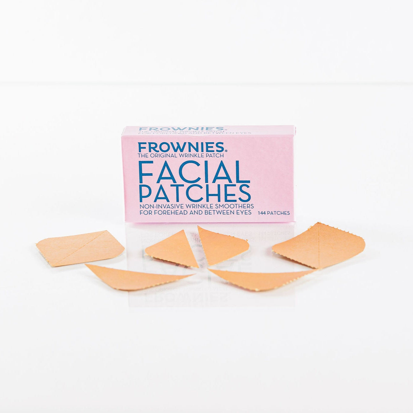 Frownies Forehead and between the eyes facial patches shown laying in front of the box on a clean white background