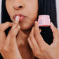 A woman with black hair applying the Frownies lip mask to her lips 