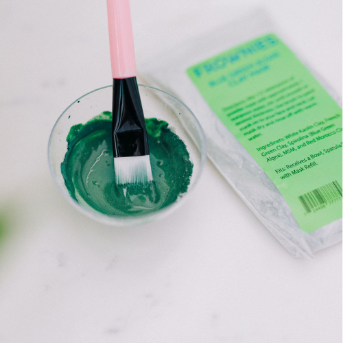 Frownies blue green algae clay mask shown after being stirred in the cup to create the final form of the mask before it is applied to the skin 