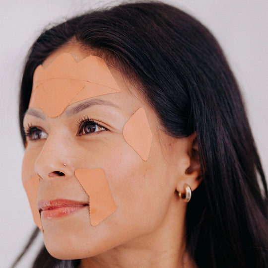 A smiling woman model wearing Frownies CEM (Corners of Eyes and Mouth) facial patches.