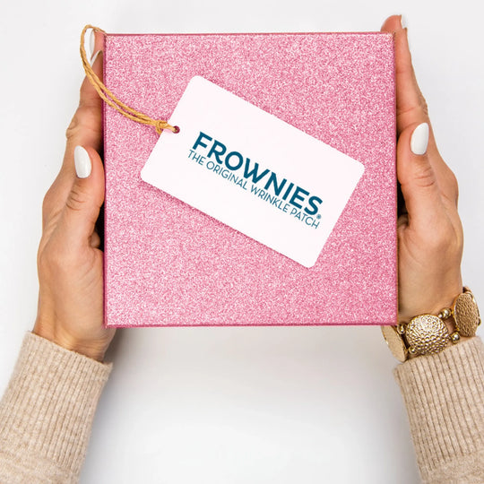 frownies the original wrinkle patch gift box, it is sparkling pink with a womans hands holding it.