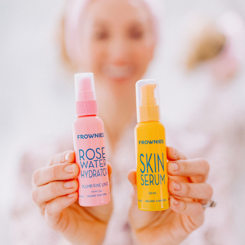 Frownies rose water hydrator and skin serum being held in a womans hands 